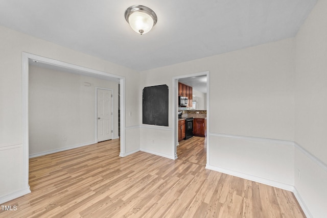 spare room with light wood-style flooring and baseboards