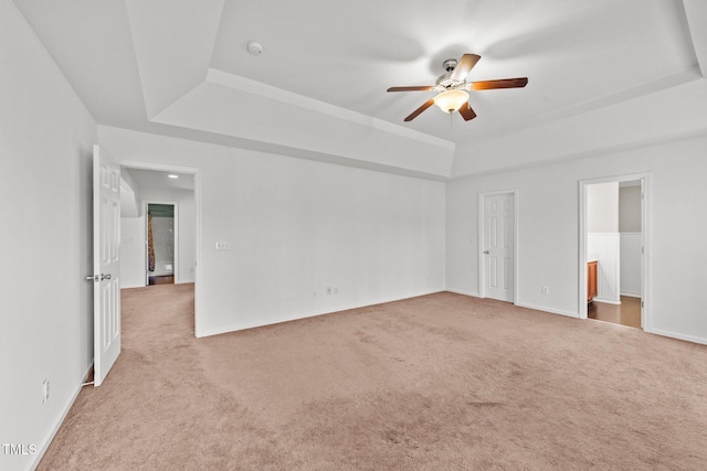 unfurnished room featuring a tray ceiling, carpet flooring, and ceiling fan