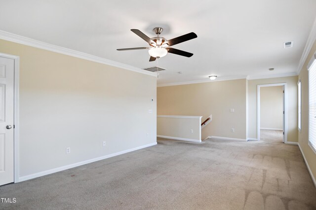 spare room featuring ornamental molding, light colored carpet, and visible vents