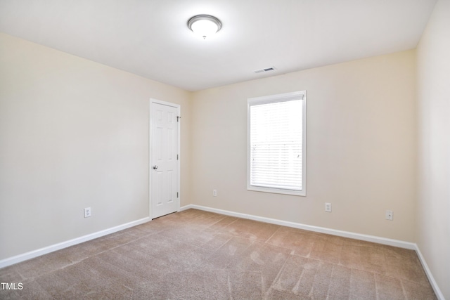 empty room with baseboards, visible vents, and carpet flooring