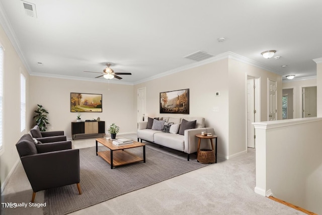 living room with crown molding, ceiling fan, baseboards, and light carpet
