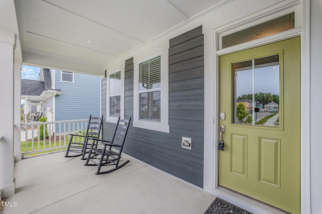 view of exterior entry featuring covered porch