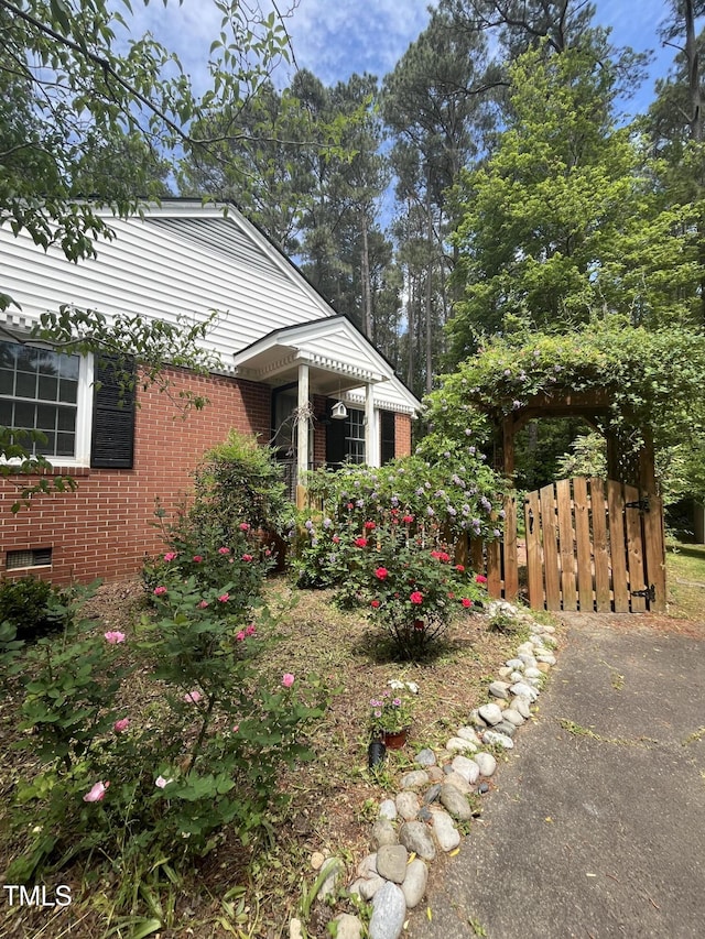 view of side of property with fence and brick siding