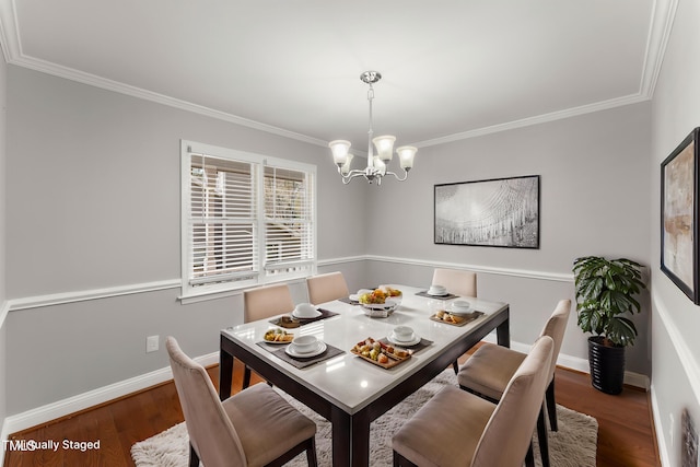 dining area featuring ornamental molding, an inviting chandelier, and wood finished floors