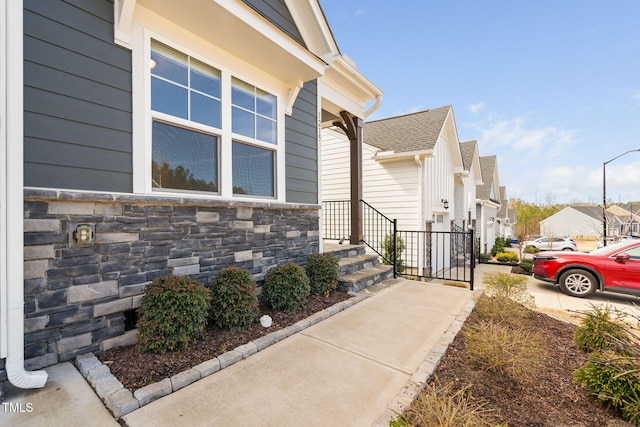 view of property exterior featuring stone siding and a residential view