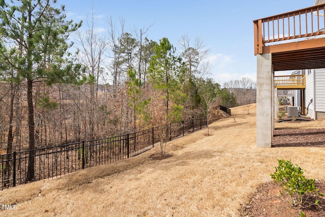 view of yard with central air condition unit and fence