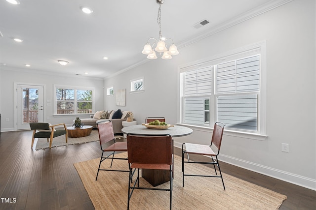 dining space featuring dark wood-style floors, baseboards, visible vents, and ornamental molding