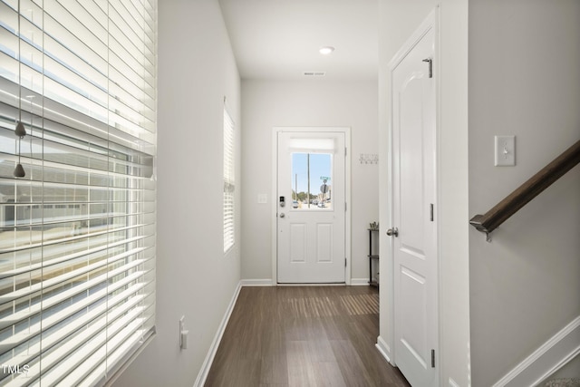 doorway to outside featuring dark wood-style floors, visible vents, stairway, and baseboards