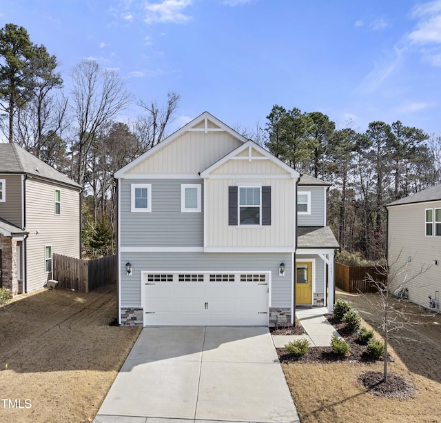 craftsman-style home featuring board and batten siding, concrete driveway, fence, and stone siding