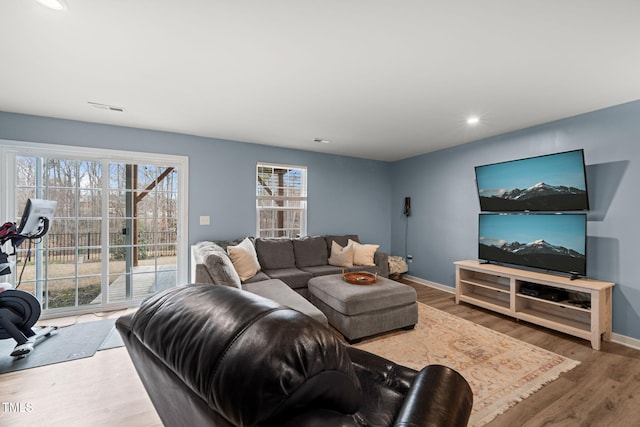 living area featuring visible vents, baseboards, and wood finished floors