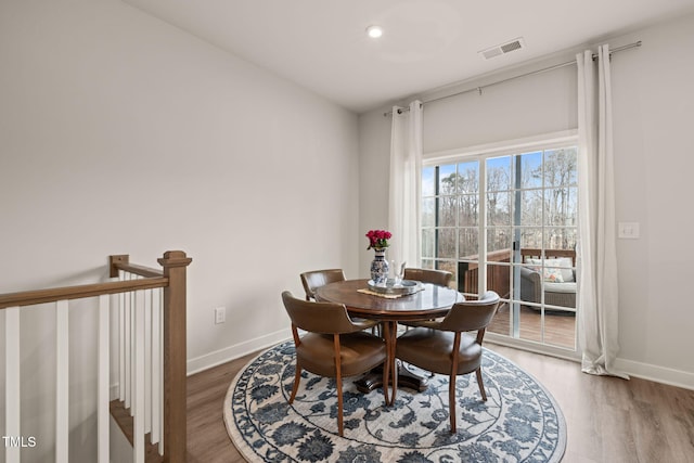 dining space with visible vents, baseboards, and wood finished floors