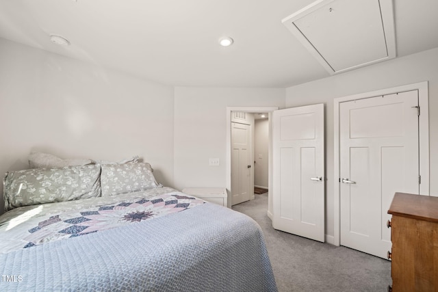 bedroom with light colored carpet and attic access