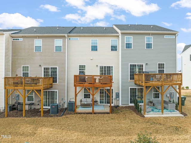 rear view of house featuring a patio area, a lawn, and central AC