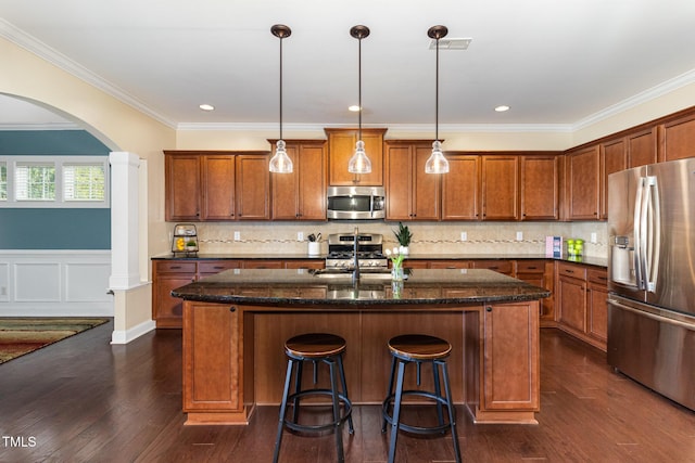 kitchen with stainless steel appliances, a sink, visible vents, and brown cabinets