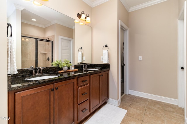 bathroom with baseboards, a shower stall, ornamental molding, and a sink