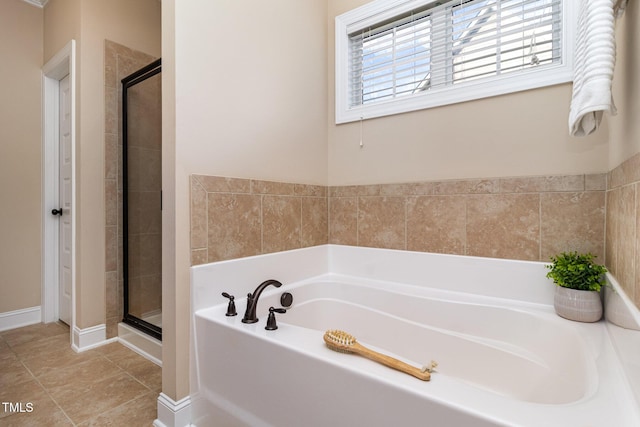 bathroom featuring a stall shower, a bath, and tile patterned floors