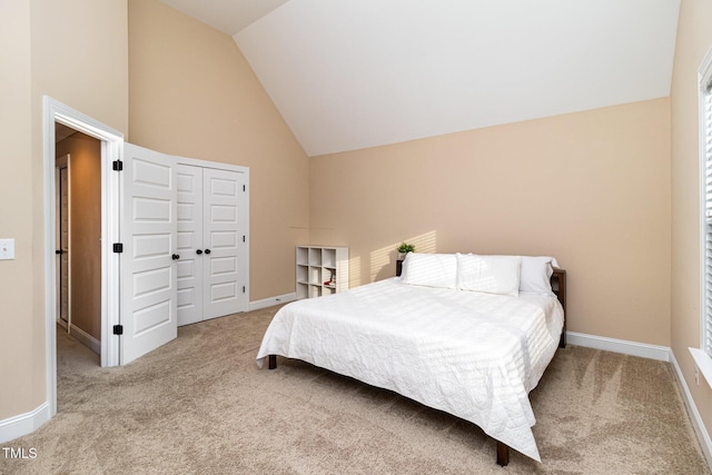 carpeted bedroom with high vaulted ceiling, a closet, and baseboards