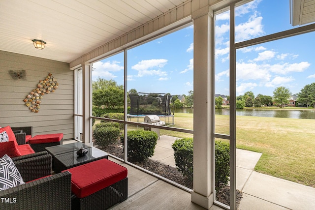 sunroom featuring a water view