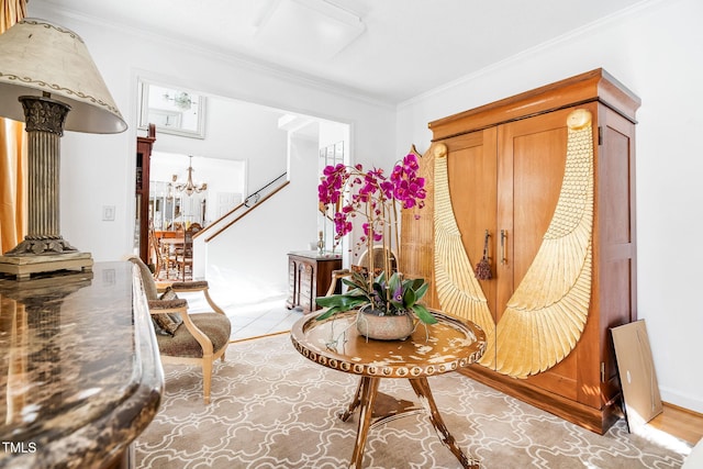 sitting room with a chandelier, ornamental molding, and ornate columns