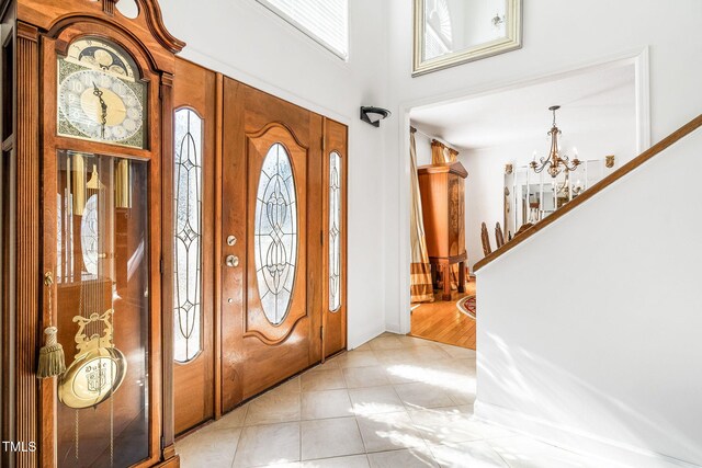 entryway featuring stairway, light tile patterned floors, and a chandelier