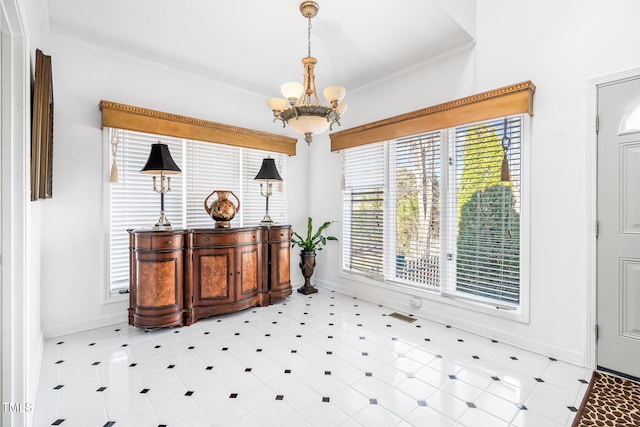 interior space with a chandelier, ornamental molding, and baseboards