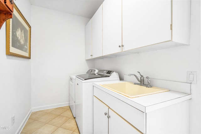 laundry area featuring light tile patterned floors, cabinet space, baseboards, independent washer and dryer, and a sink