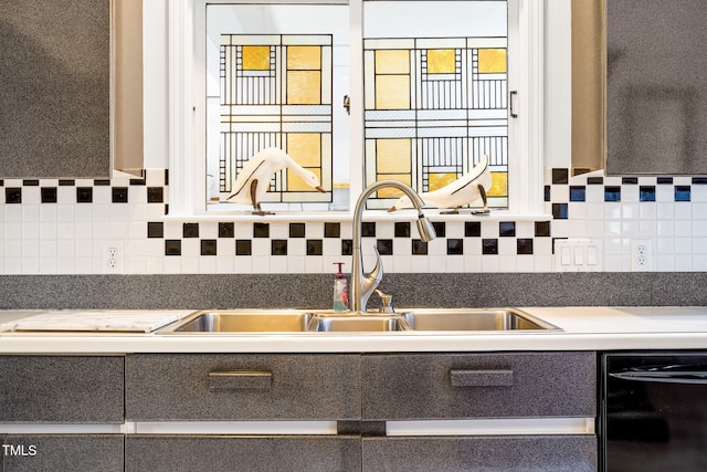 kitchen with dishwasher, tasteful backsplash, dark countertops, and a sink