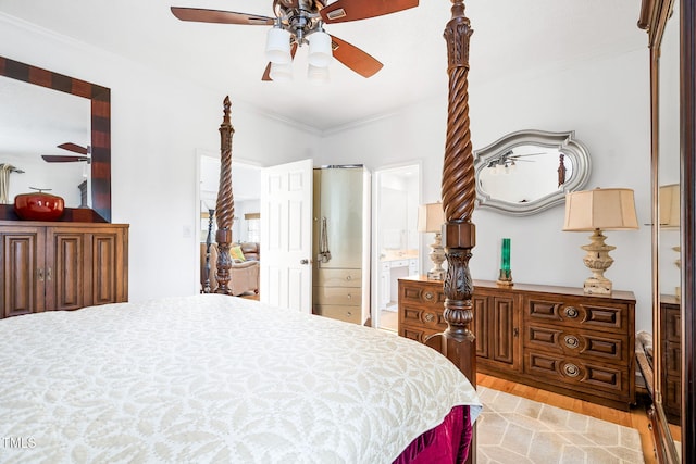 bedroom featuring ensuite bathroom, ornamental molding, a ceiling fan, and light wood-style floors