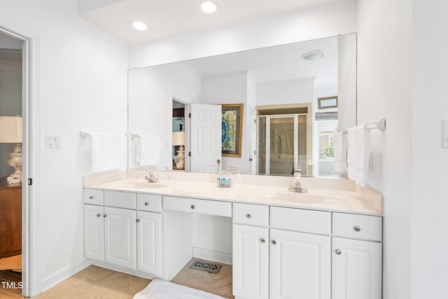 bathroom featuring tile patterned floors, a sink, a shower stall, and double vanity