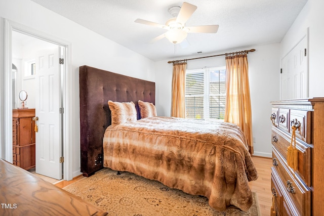 bedroom featuring visible vents, ceiling fan, a textured ceiling, light wood-type flooring, and baseboards