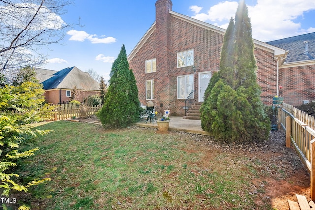 back of house featuring entry steps, brick siding, a lawn, and fence private yard