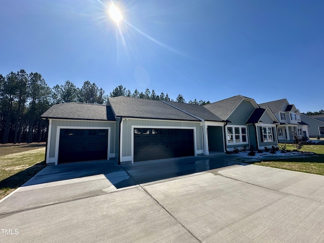 ranch-style home featuring an attached garage, board and batten siding, driveway, and a shingled roof