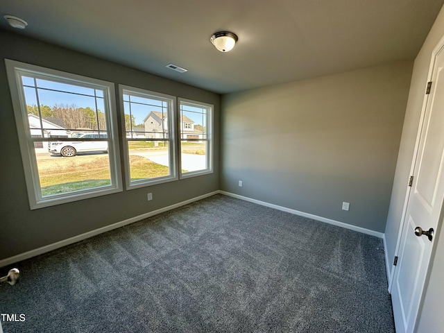 interior space with visible vents, baseboards, and dark carpet