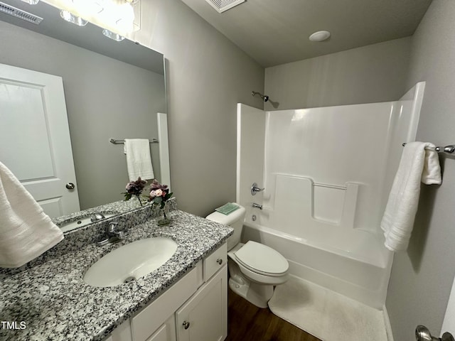 bathroom featuring vanity, wood finished floors, visible vents, tub / shower combination, and toilet