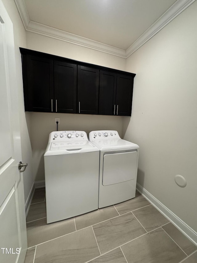 laundry area with ornamental molding, washer and clothes dryer, cabinet space, and baseboards