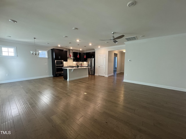 unfurnished living room with visible vents, dark wood finished floors, crown molding, and ceiling fan with notable chandelier