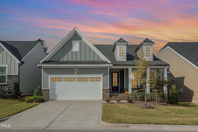 view of front facade featuring an attached garage, brick siding, driveway, a front lawn, and board and batten siding