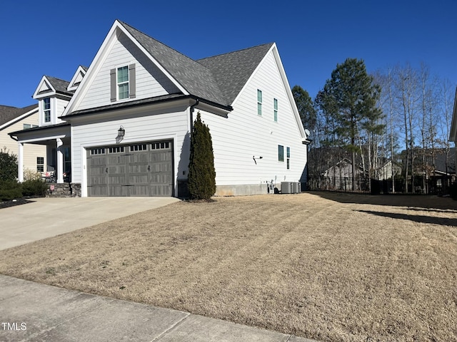 view of front of house featuring cooling unit, roof with shingles, driveway, and an attached garage