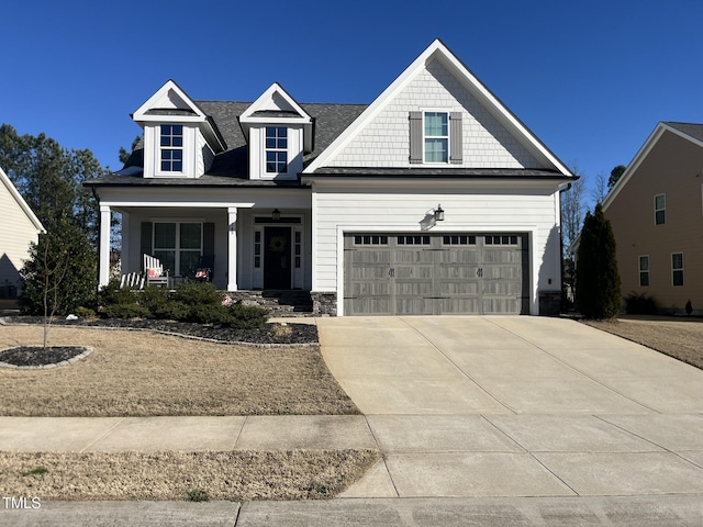 view of front of house with covered porch, concrete driveway, and a garage