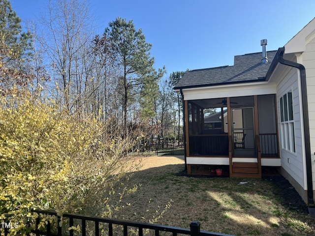 view of yard featuring a sunroom and fence