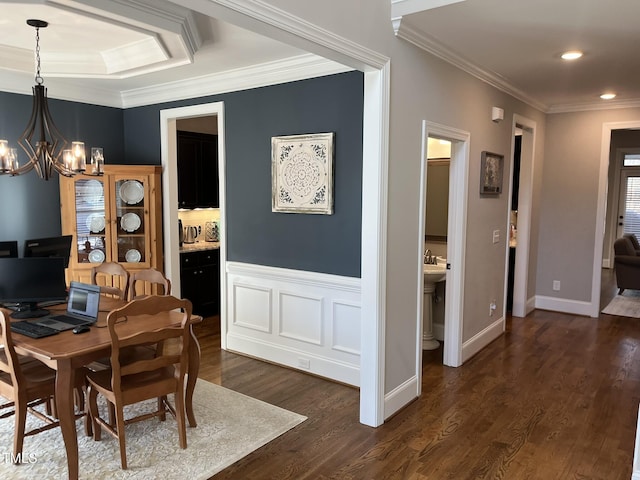 dining room with crown molding, dark wood finished floors, and a notable chandelier