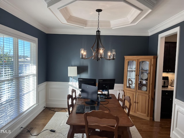 dining room featuring wainscoting, a raised ceiling, a notable chandelier, and wood finished floors