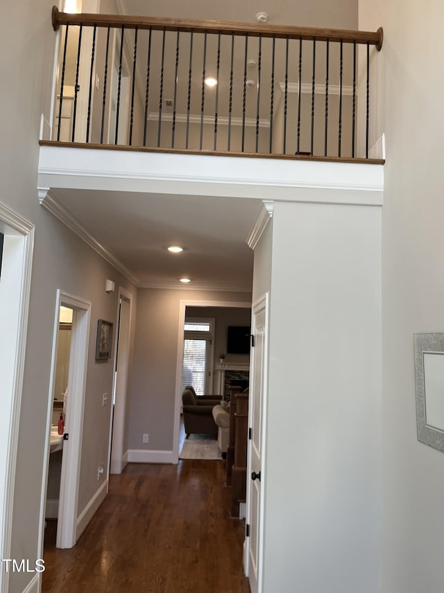 corridor featuring dark wood finished floors, crown molding, baseboards, and recessed lighting