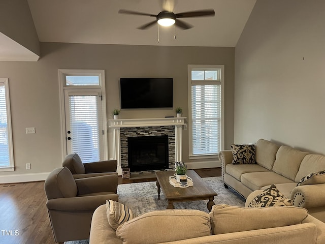 living area featuring a wealth of natural light, lofted ceiling, ceiling fan, and wood finished floors