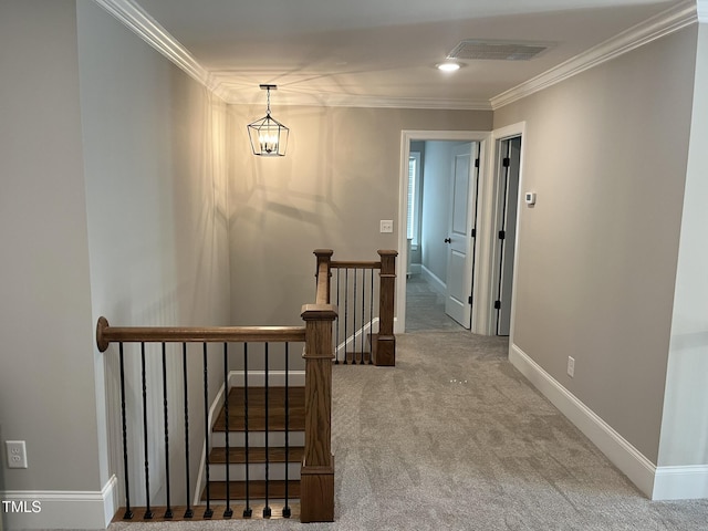 corridor featuring visible vents, carpet floors, ornamental molding, and an upstairs landing