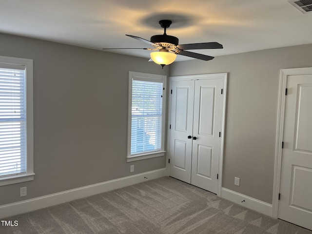 unfurnished bedroom with carpet floors, a closet, visible vents, and baseboards