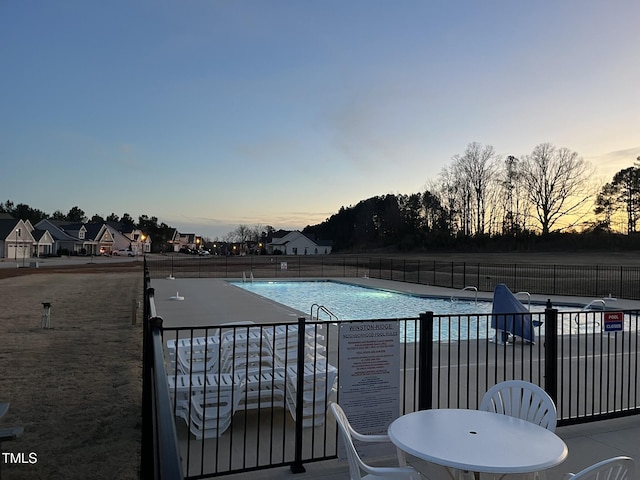 community pool with a patio and fence