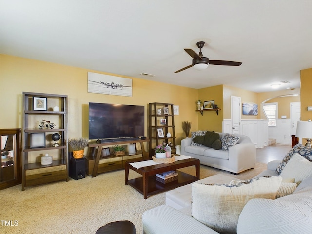 living room with a ceiling fan, arched walkways, and visible vents