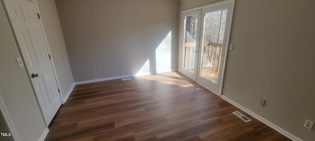 interior space featuring dark wood-style floors, visible vents, and baseboards