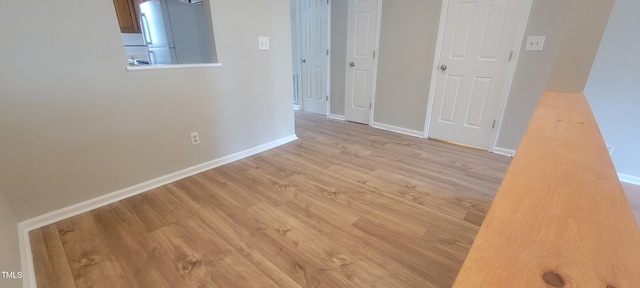 unfurnished room with wood finished floors and baseboards